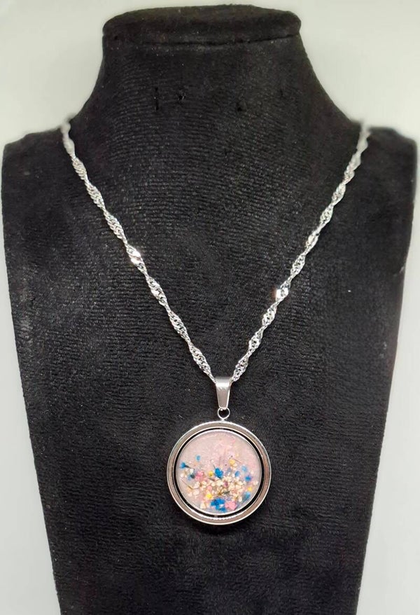 Ketting zilverkleurig met een tweedelige bedel gevuld met witte epoxy en droogbloemen