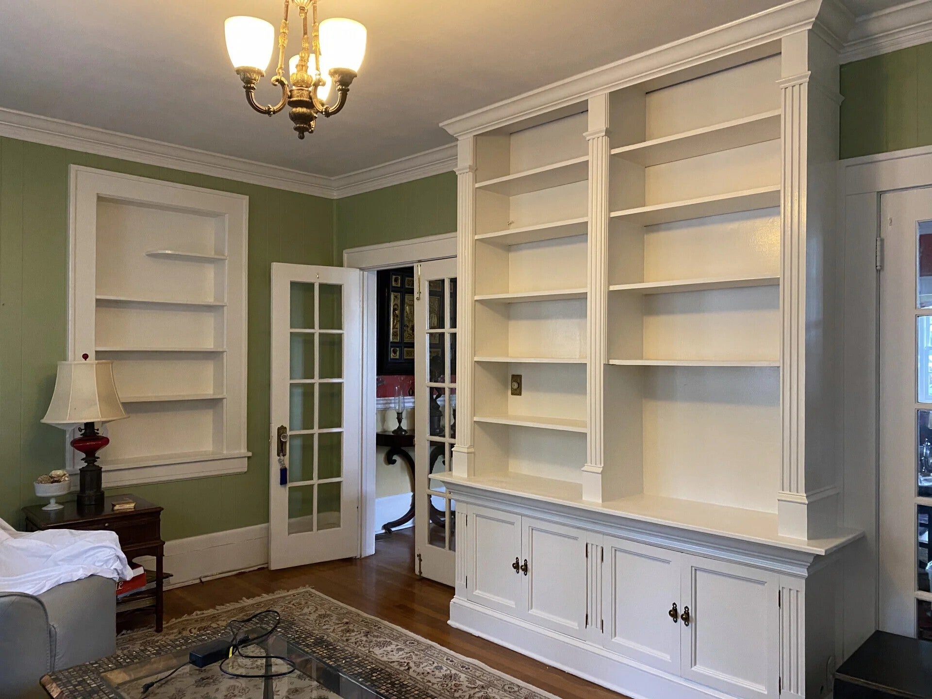 built-in shelves with new white paint in jacksonville living room with earthy green walls