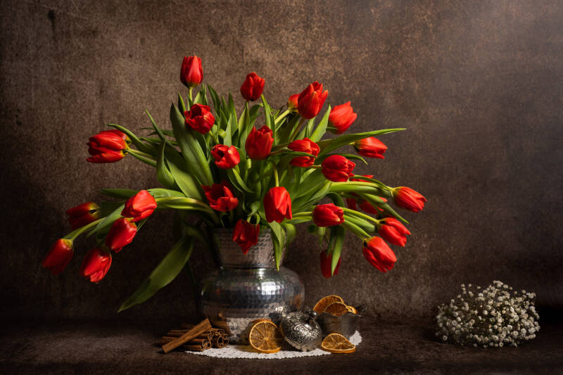 Modern stilleven met rode tulpen in een zilveren vaas. Laat je muren spreken met een prachtig verhaal vertellend stilleven van John van de Gazelle. Want, één beeld zegt meer dan duizend woorden.