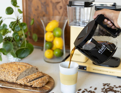 Iemand die filterkoffie inschenkt in een kop