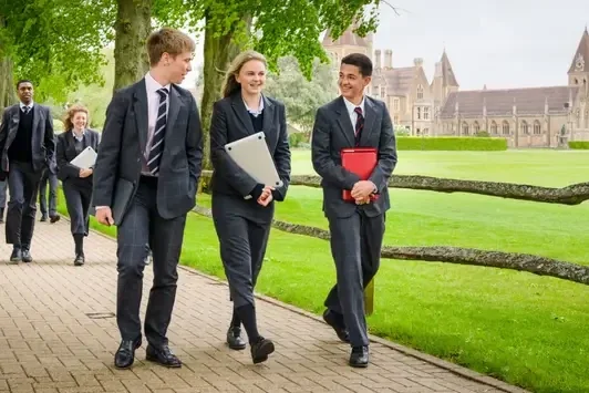 Smartly dressed senior school students walking across campus between academic lessons.