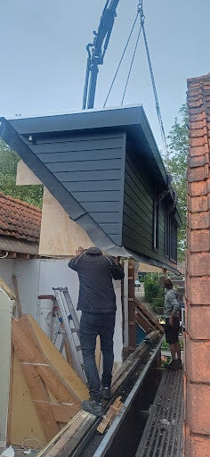 Antraciete prefab dakkapel van 7 meter aan de zijkant van een woning in Kloetinge