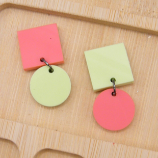 Photo of mismatched earrings. One has a coral square with pistachio cirlce and the other has a pistochio square with a coral circle
