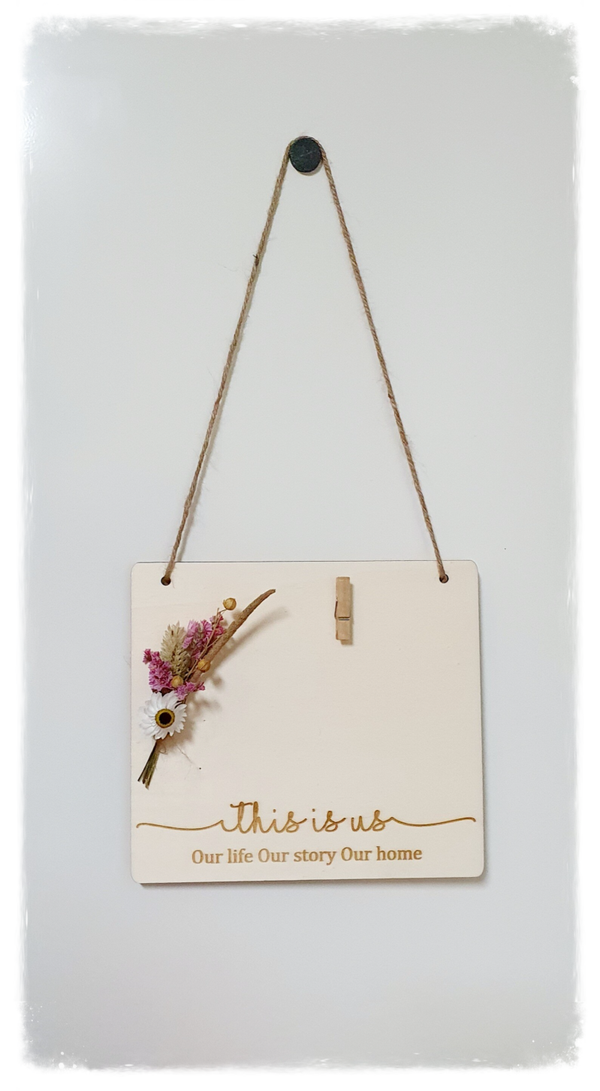 Tekstbord 'This is us...' met droogbloemen en plaats voor foto