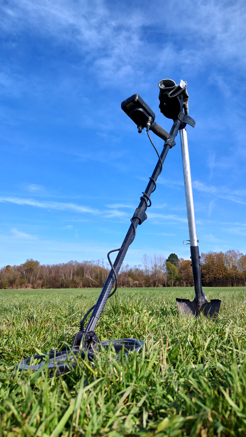 Sondeln: Detektor mit Spaten auf Wiese