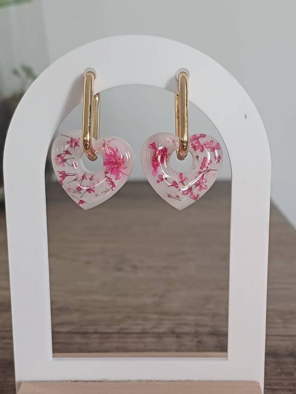 Cœurs avec fleurs séchées roses et fond blanc