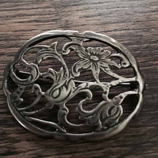 Broche bewerkt met bloemen.