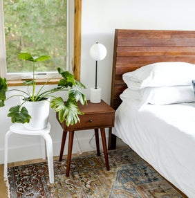 een kille witte slaapkamer met een houten bedbord