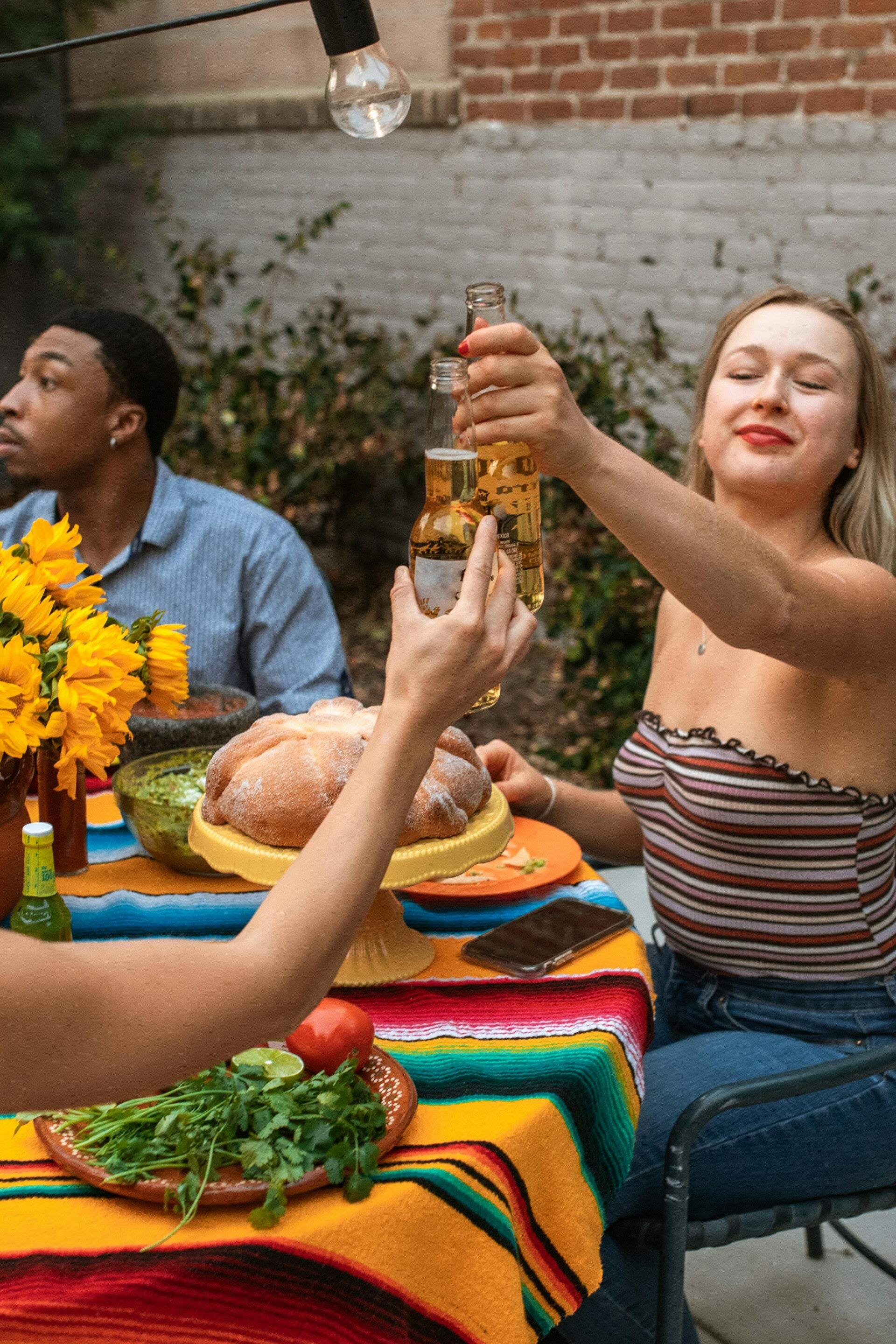 Tuinplezier - gezellig tafelen met verschillende mensen die klinken op een leuke tijd samen. Kleurrijk interieur met tuin op de achtergrond