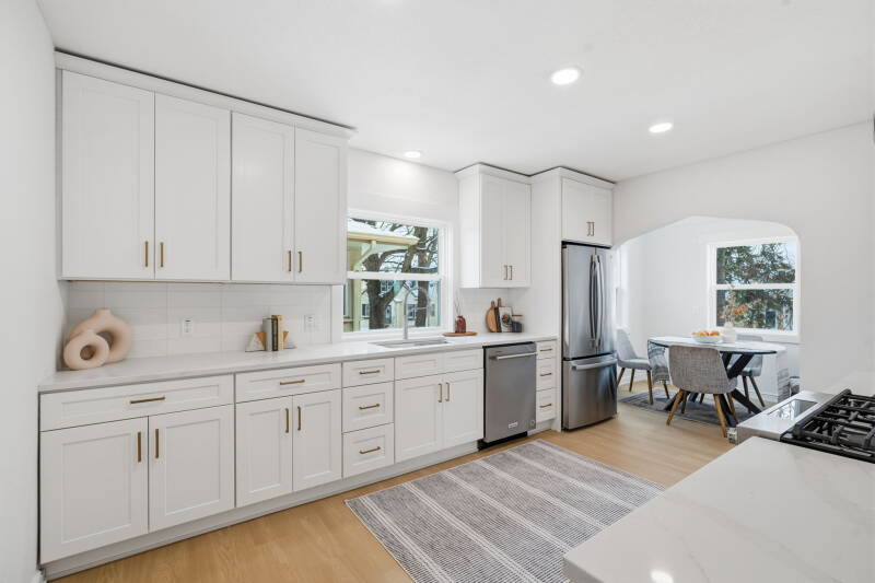 Luxury kitchen remodel in Edina Minnesota featuring custom white cabinets, quartz countertops, and white oak LVP flooring