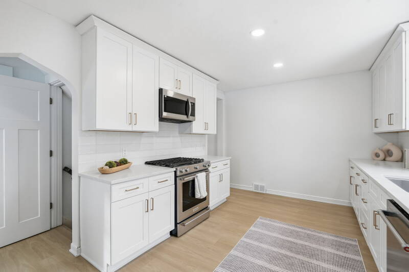 Luxury kitchen remodel in Edina Minnesota featuring custom white cabinets, quartz countertops, and white oak LVP flooring