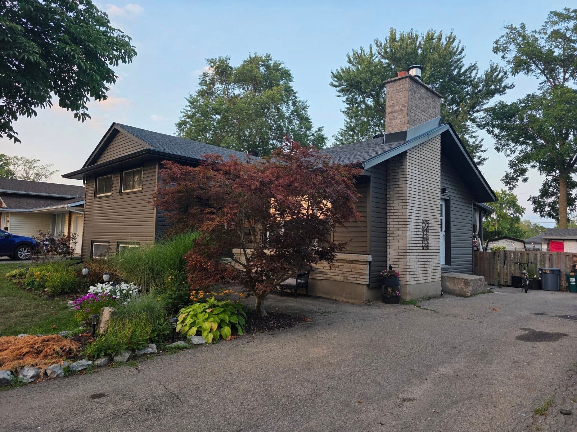 Home renovation by Exteriors Near Me. Exterior of home with brown roof, horizontal green siding. Roofing_soffit_fascia_eavestroughs_capping_flashing