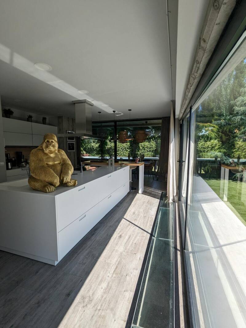 cocina moderna blanca estilo nordico moderno minimalista con una escultura de mono dorado chalet individual en venta España