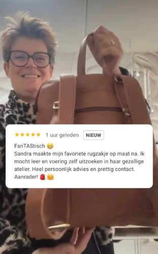 Eigenaar en maker Sandra Creaties met een handgemaakte rugzak in haar handen en een prachtige review | Sandra Creaties