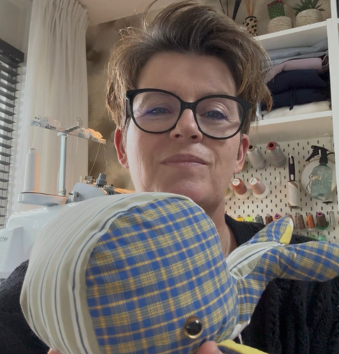 Sandra met een troostknuffel in haar handen gemaakt van dierbare kleding.