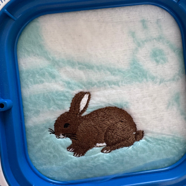 Een giletje die in de borduurmal zit en geborduurd wordt met een konijntje Sandra Creaties