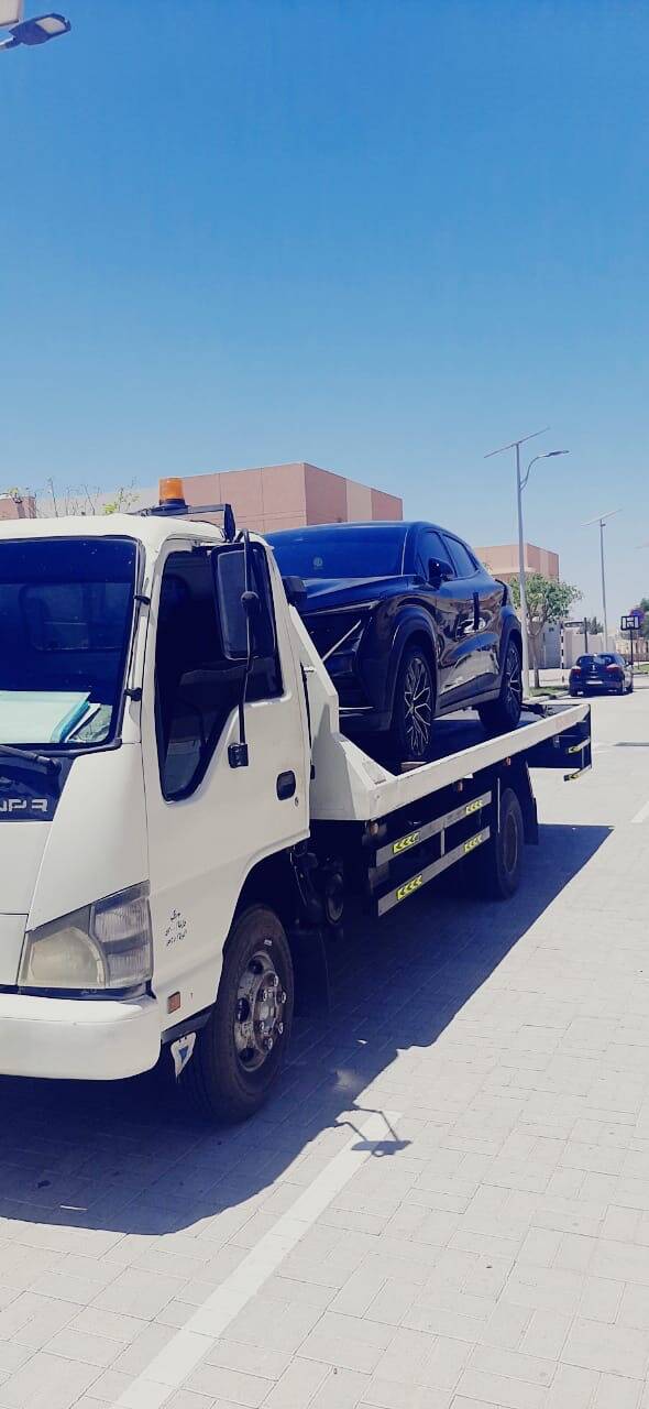 Hydraulic low-bed recovery carrier safely transporting a luxury sports vehicle near Yas Island, Abu Dhabi