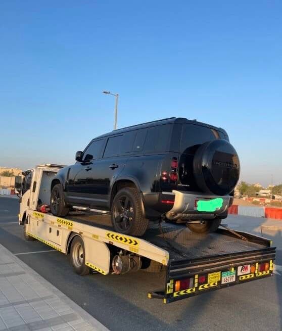 Flatbed recovery truck transporting a vehicle in Abu Dhabi