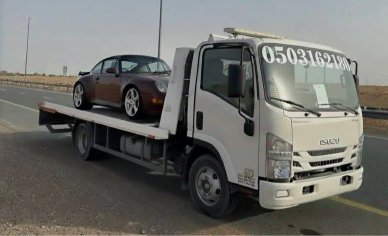 Hydraulic low-bed recovery carrier safely transporting a luxury sports vehicle near Yas Island, Abu Dhabi