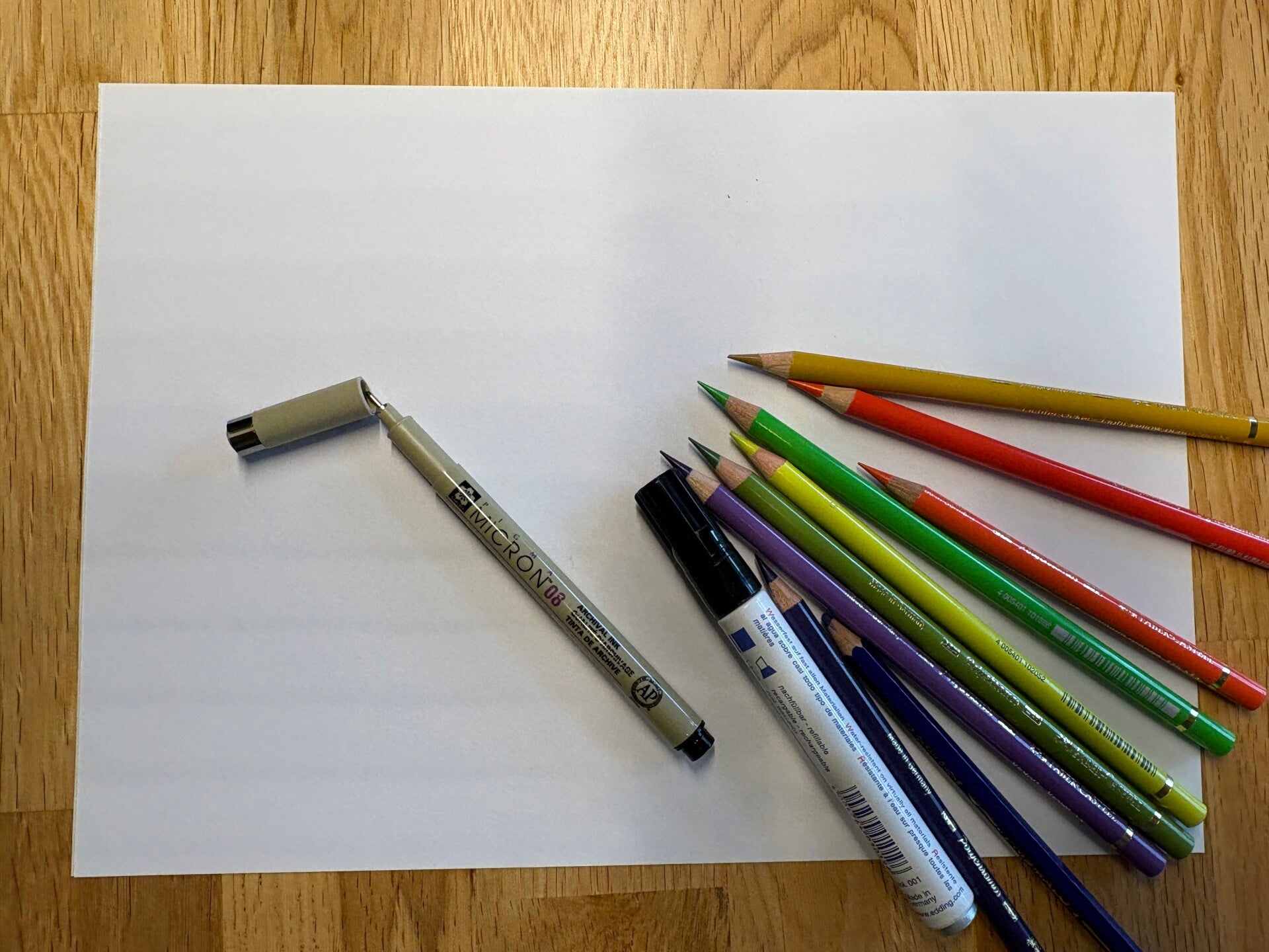 Blatt Papier mit Filzstift, Feinliner und Buntstiften