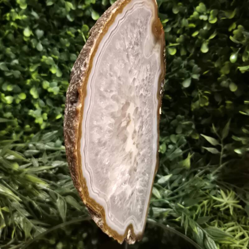 Agaat op zwarte standaard van ca. 24 cm hoog en 1360 gram. Gepolijst aan voorzijde, ruw aan achterzijde.