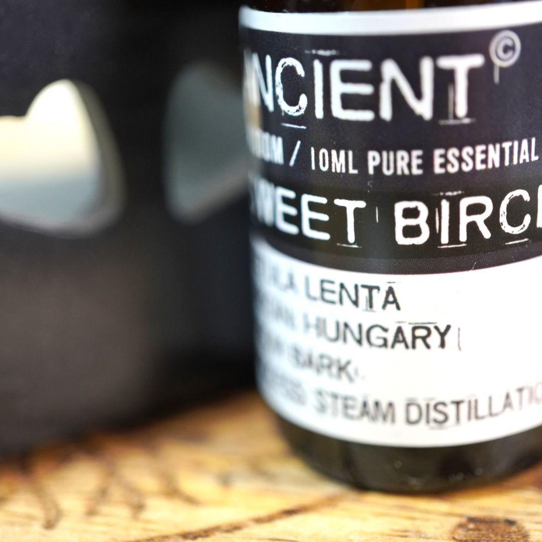 In een oudroze aroma diffuser ligt : Witte Berk essentiële olie van Ancient Wisdom, 10 ml.