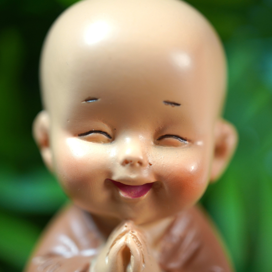 Beeldje van een baby monnik, vrolijk en blij