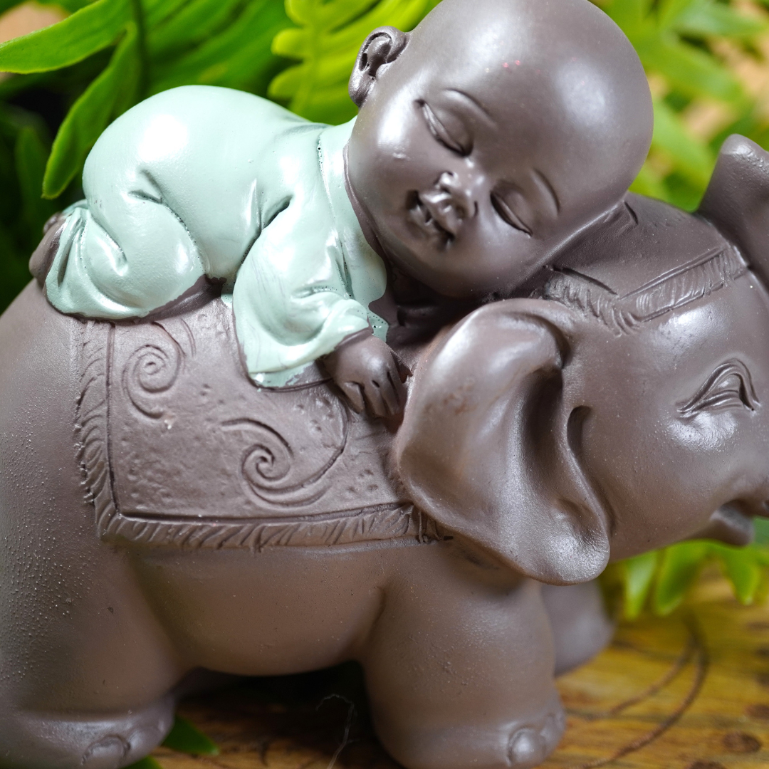 Baby monnik op de rug van een feng shui geluksolifant, beeldje van polyresin