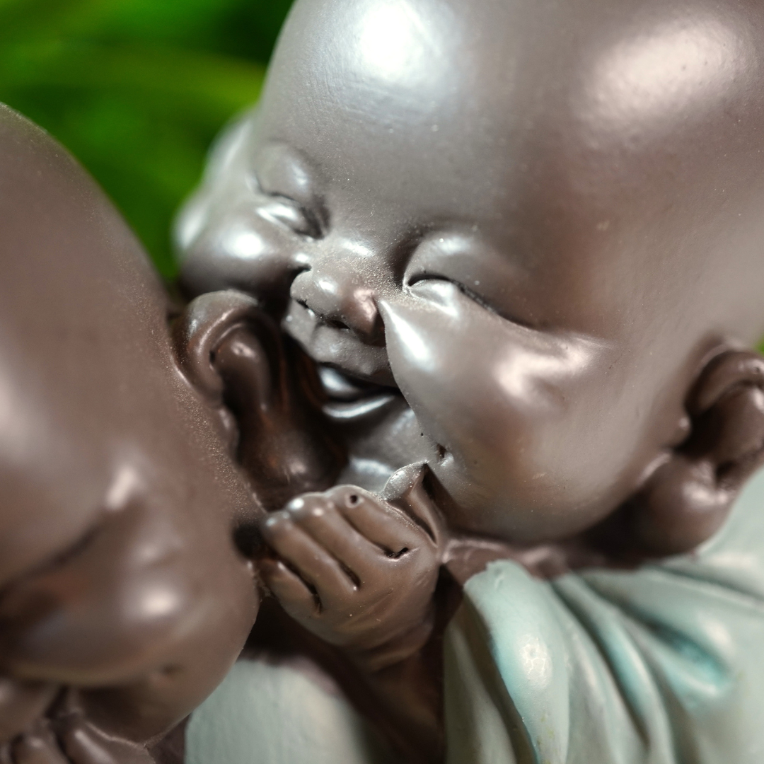 Beeldje van 2 fluisterende baby monniken, staat symbool voor vriendschap
