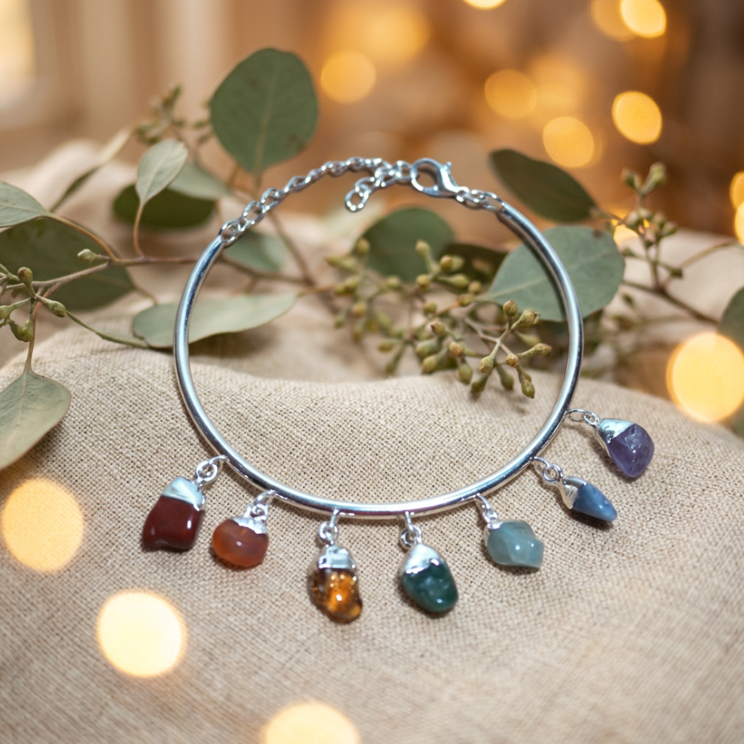 Verstelbare verzilverde chakra armband met chakra trommelsteentjes als bedeltjes.