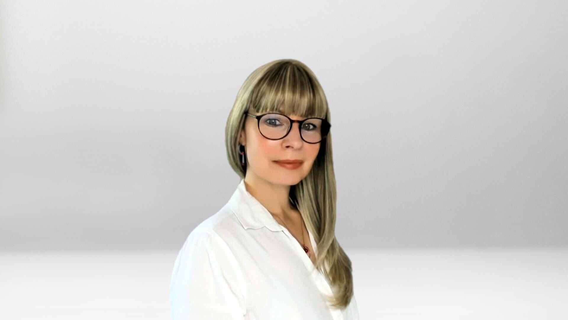 Jana Lorenz mit langen blonden Haaren, trägt weiße Bluse und goldene Ohrringe, Halskette mit rundem roten Anhänger, Kontext Mediumship  & Research Institut für Medialität & Afterlife Forschung