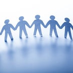 Acht ausgeschnittene Figuren aus blauen Papier halten sich an den Händen und stehen in einer Reihe, Kontext Mediumship & Research Institut für Medialität & Afterlife Forschung.