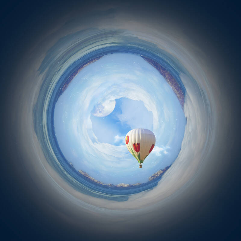 Ein Heißluftballon mit roten Herzen schwebt in einem spiralförmigen, blauen Himmel über einem Gewässer, Kontext Blog Mediumship & Research Institut für Medialität & Afterlife Forschung.