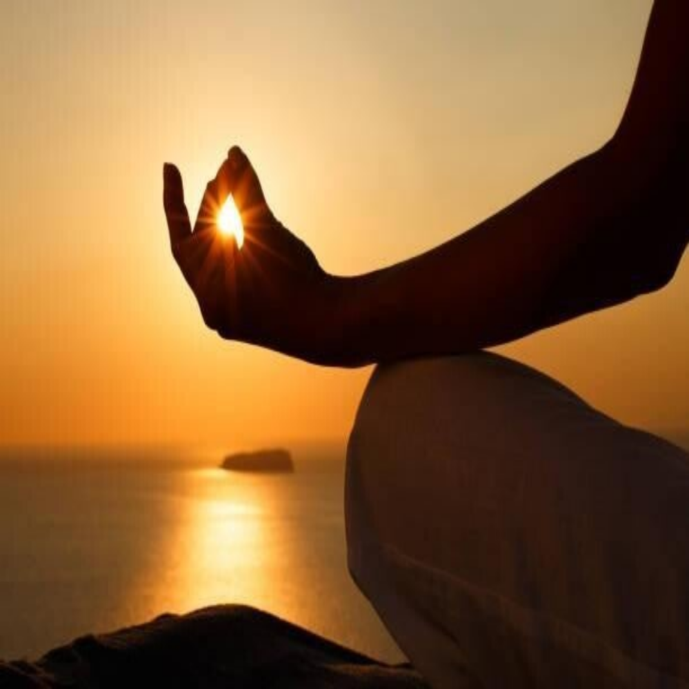 Silhouette einer meditierenden Person im Lotussitz vor einem leuchtenden goldenen Ring, umgeben von Wolken und Lichtstrahlen, Kontext Blog Jenseitskontakte Jana Lorenz.