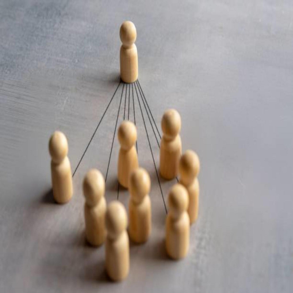 Acht Papiersilhouetten von Menschen, die sich an den Händen halten, auf einer glatten Oberfläche, Kontext Blog Jenseitskontakte Jana Lorenz.
