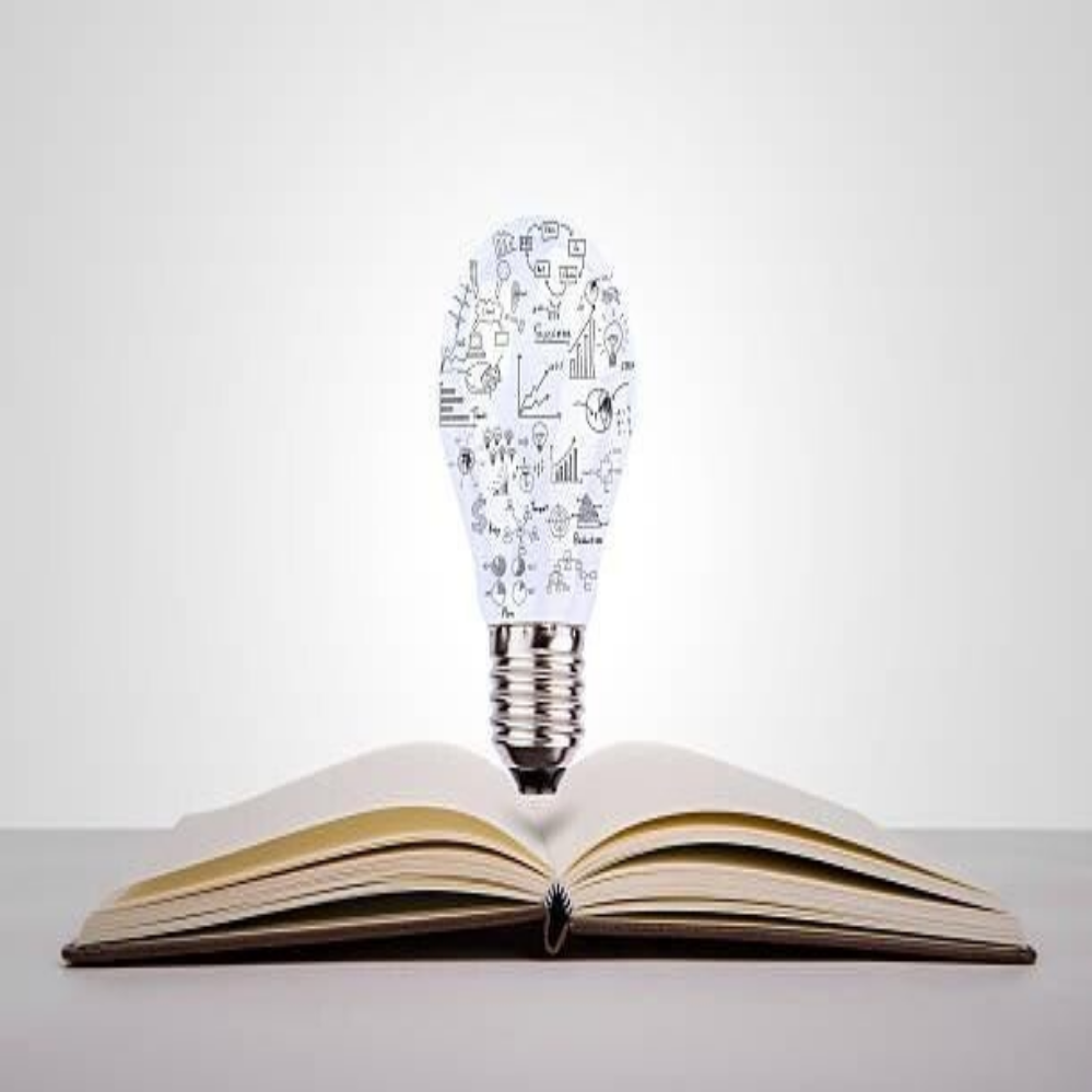 Eine geöffnete Buchseite mit einer Glühbirne in der Mitte, aus der Grafiken und Symbole wie Diagramme und Sprechblasen aufsteigen, Kontext Blog Jenseitskontakte Jana Lorenz.