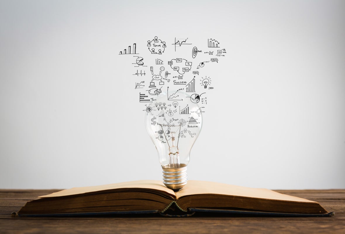 Eine geöffnete Buchseite mit einer Glühbirne in der Mitte, aus der Grafiken und Symbole wie Diagramme und Sprechblasen aufsteigen, Kontext Blog Mediumship & Research Institut für Medialität & Afterlife Forschung.