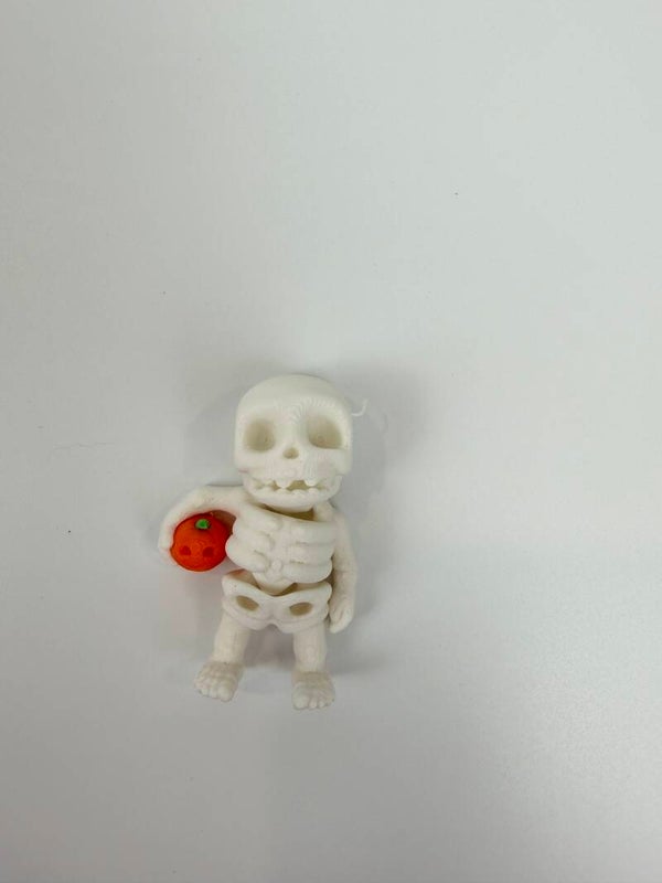 Mini holding pumpkin skeleton