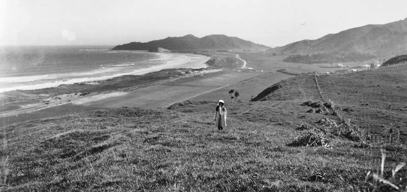 A young Winifred Lysnar posed for local photographer Wiulliam Crawford in 1908 as he took this panoramic image of Wainui Beach looking north from the Okitu hills.