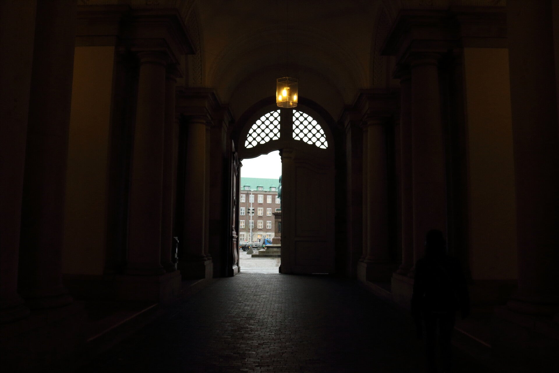 Passaggio in penombra con una porta già aperta verso l'esterno, simbolo delle possibilità che possono emergere quando smettiamo di spingere e iniziamo ad osservare.