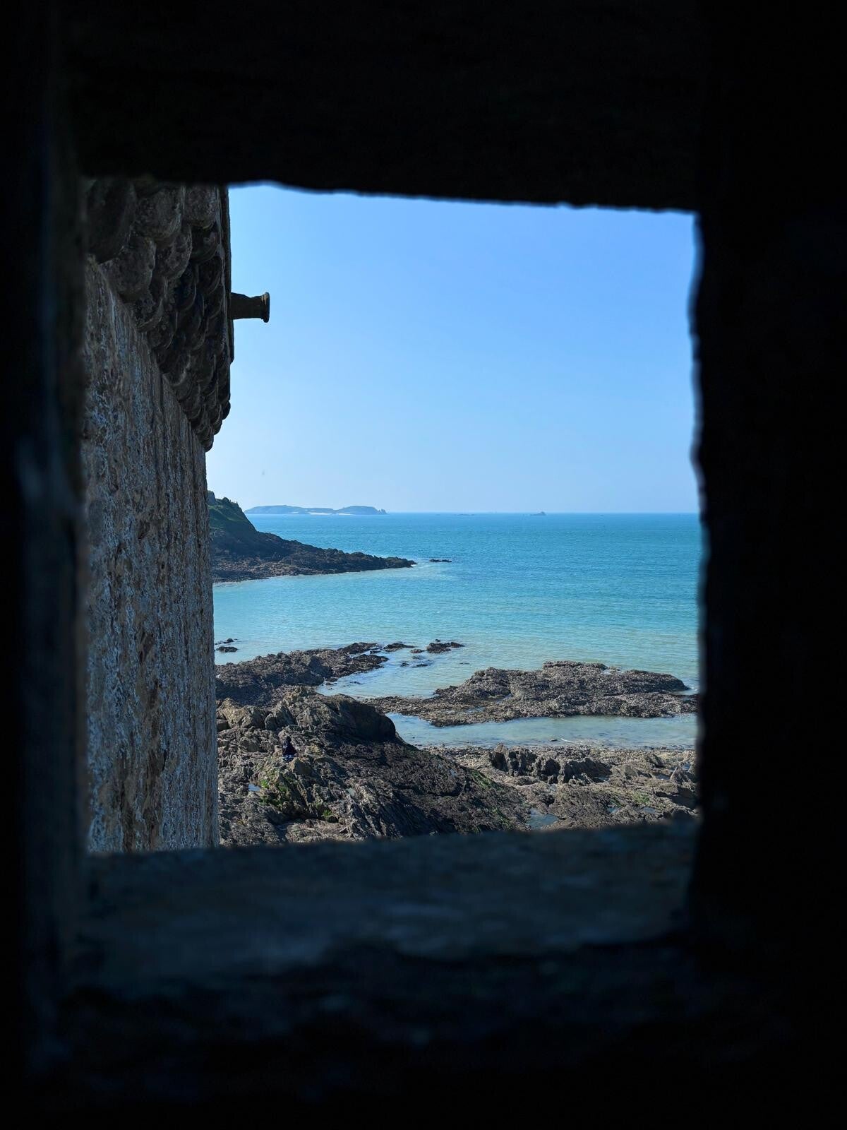 Vista del mare attraverso una stretta apertura nella roccia, simbolo di uno sguardo che si restringe e della possibilità di ampliarlo tornando al momento presente.