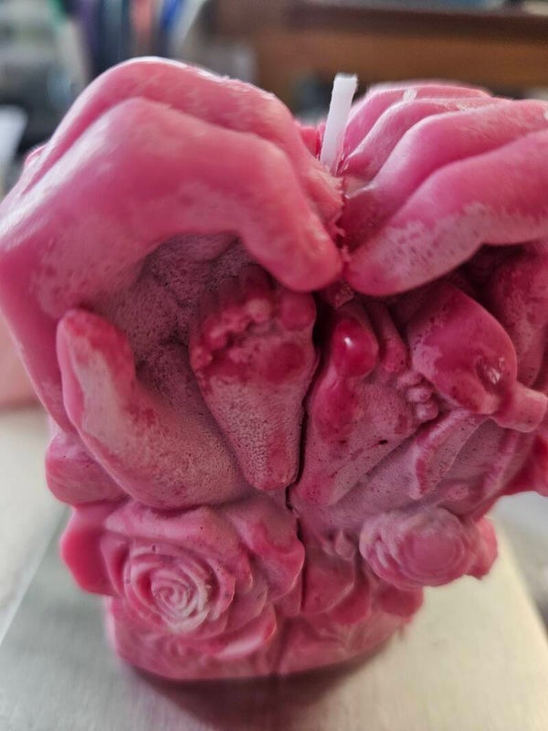 Pieds de bébé dans les mains d'un adulte formant un cœur