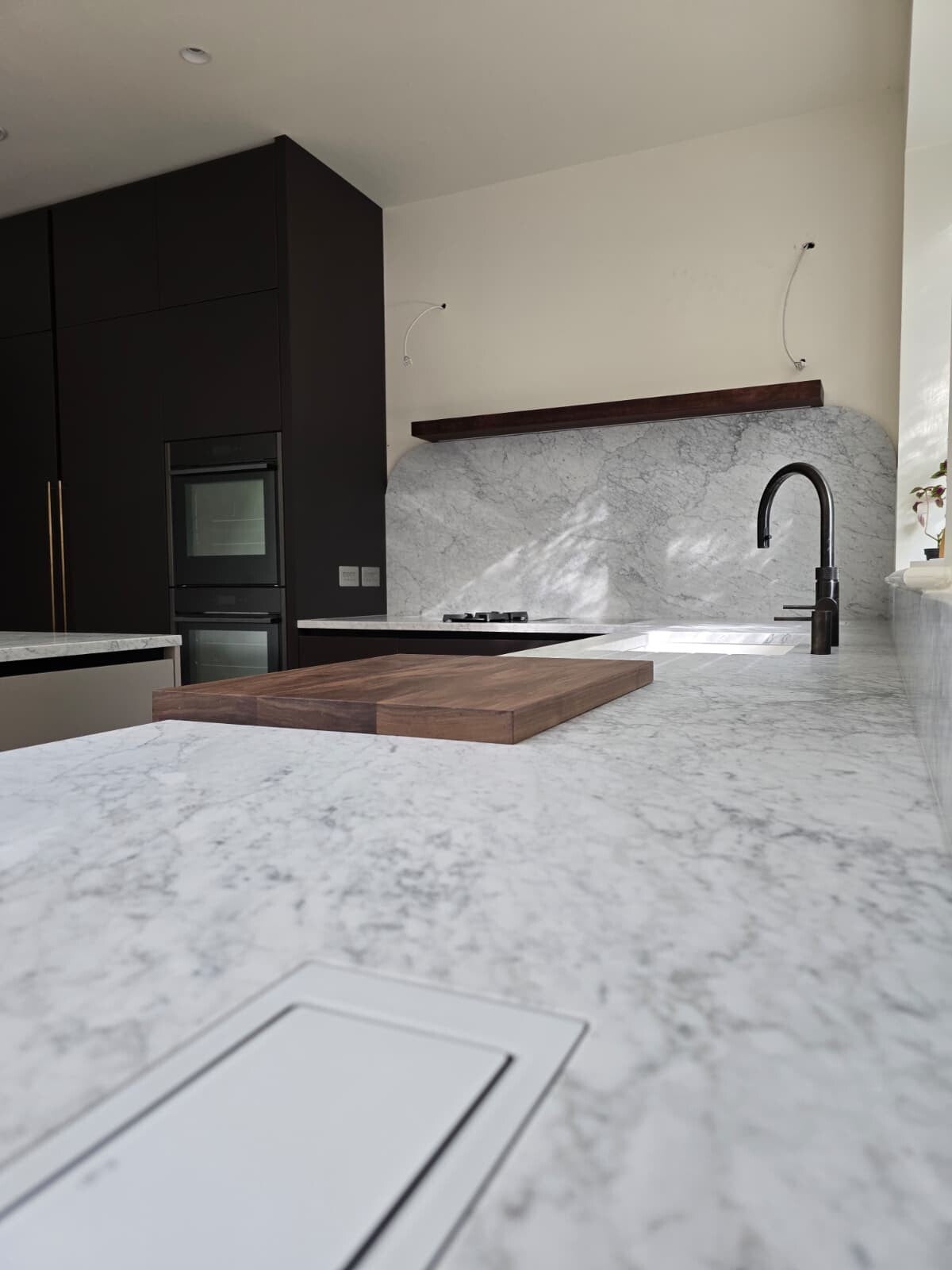 Finished bespoke Dublin 4 kitchen with dark cabinetry and veined worktops