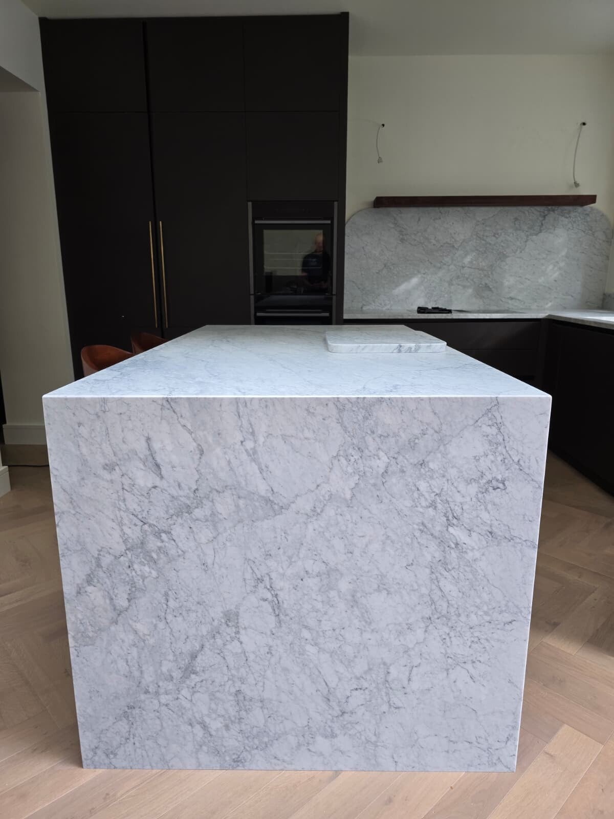 Bespoke Dublin 4 kitchen with dark cabinetry and a veined waterfall-style island