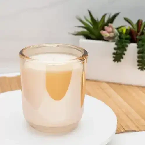 Black marble candle and white marble candle  with green plant decor on a white background 