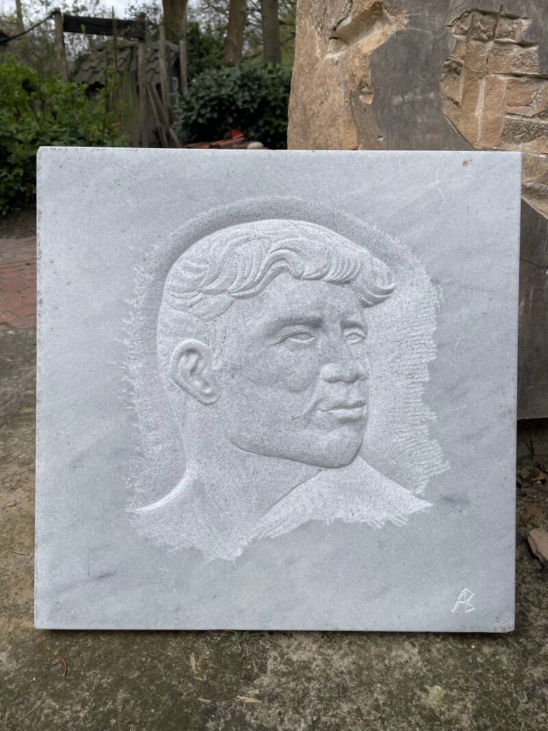 Relief mannelijk gezicht in wit marmer