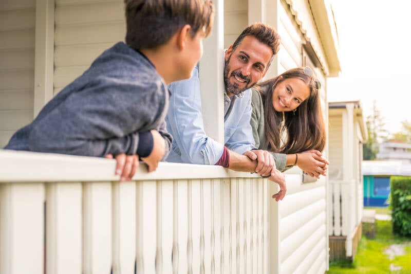 Mietunterkünfte Seecamping Lampele am Ossiachersee – Familie entspannt auf der Terrasse eines Mobilheims