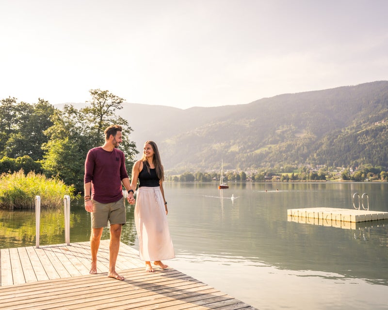 Die Ruhe und die Sonne genießen – zwei Liebende am Badesteg des Seecamping Lampele am Ossiachersee