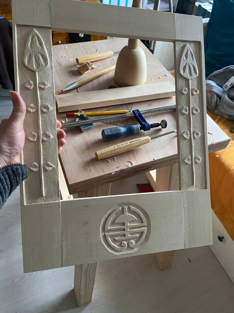 Ruwe houten lijst met bok en gereedschap in achtergrond