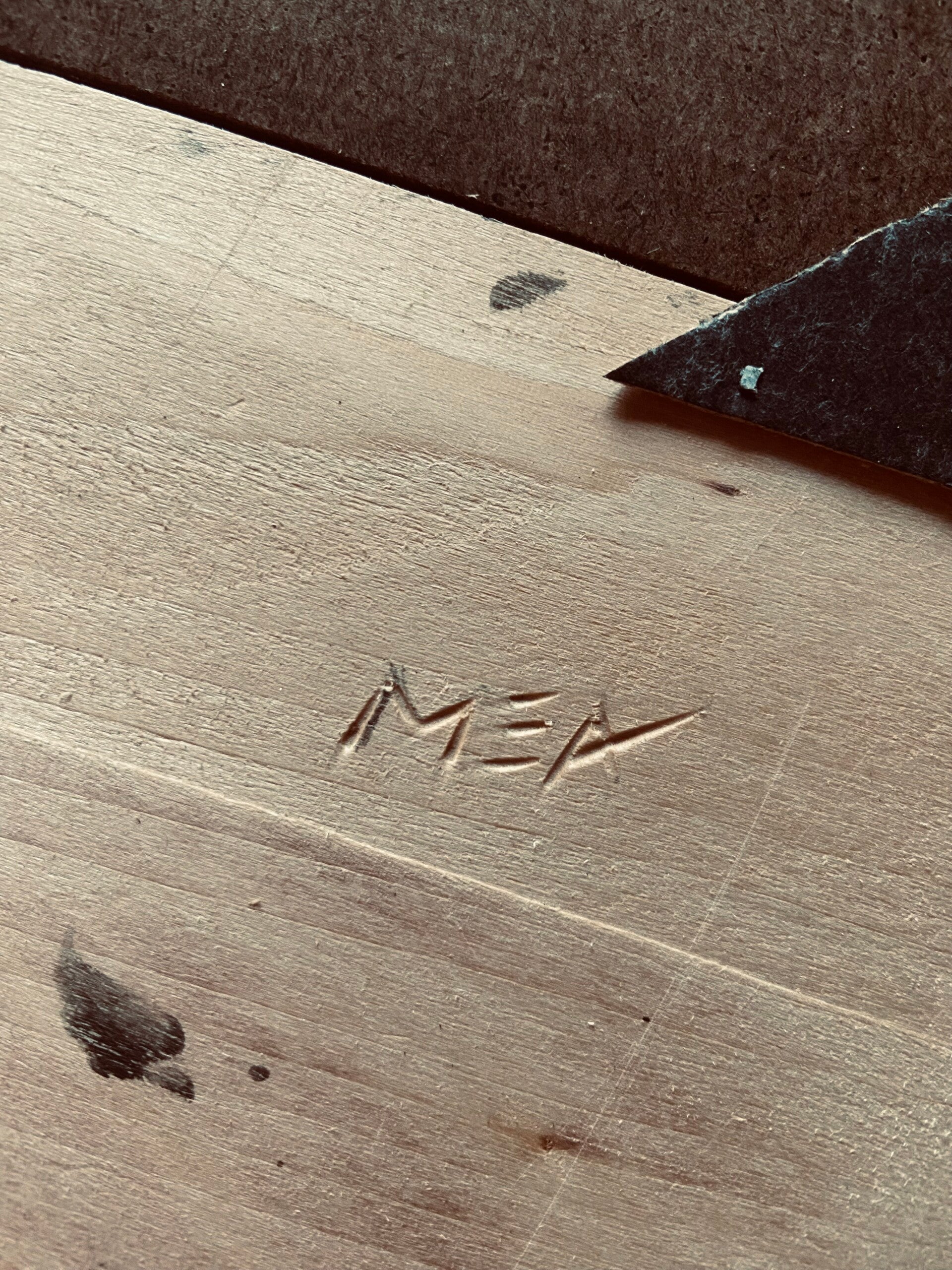 Achterkant van lijst met gebeitelde handtekening